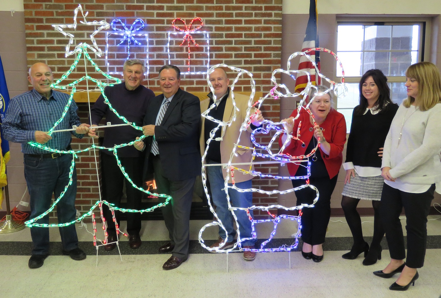 From left, Assemblyman Angelo Morinello, Jerry Wolfgang, Town of Niagara Supervisor Lee Wallace, Chris Woods, Janiene Ennis-Garcia, Meghan Ayers and Suzanne Kennedy pose with some of the lighting displays for this year's `Noel at Niagara.` (Photo by David Yarger)
